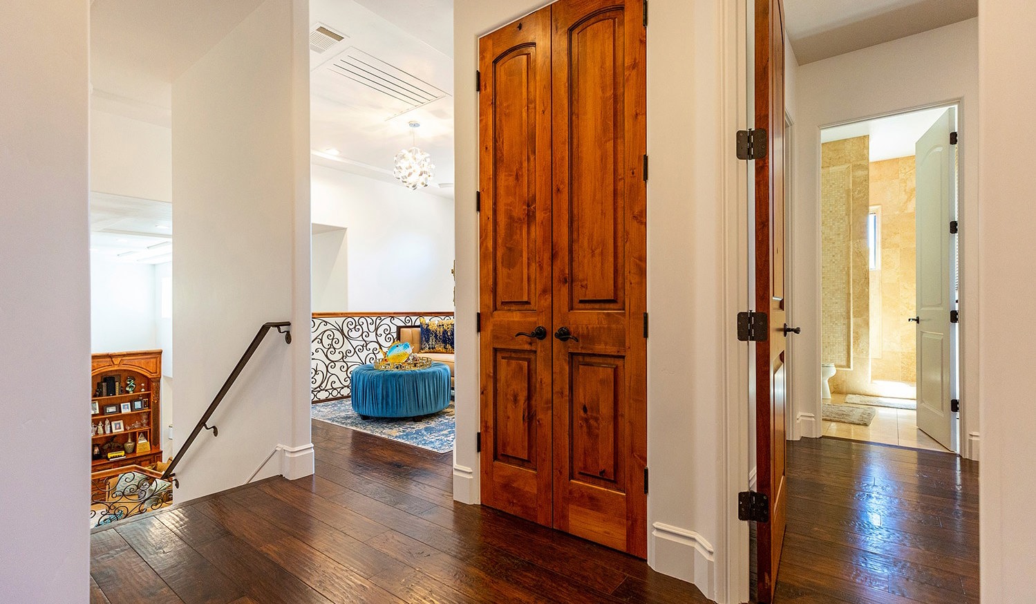 Interior hallway of home with white walls and dark wood floors