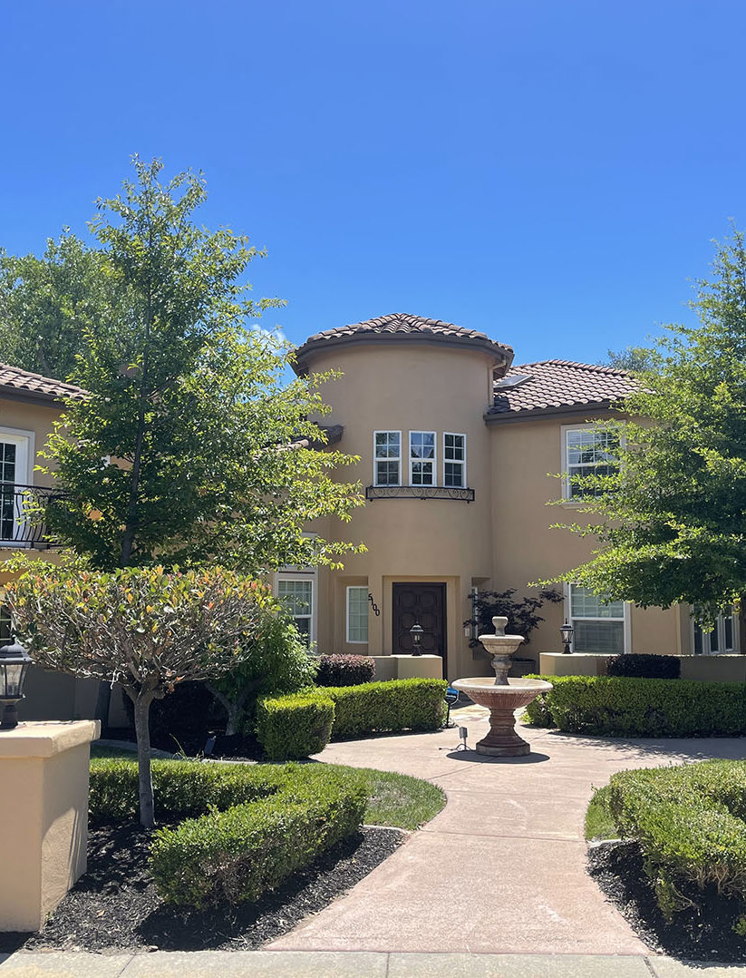 Spanish style home with fountain and landscaping