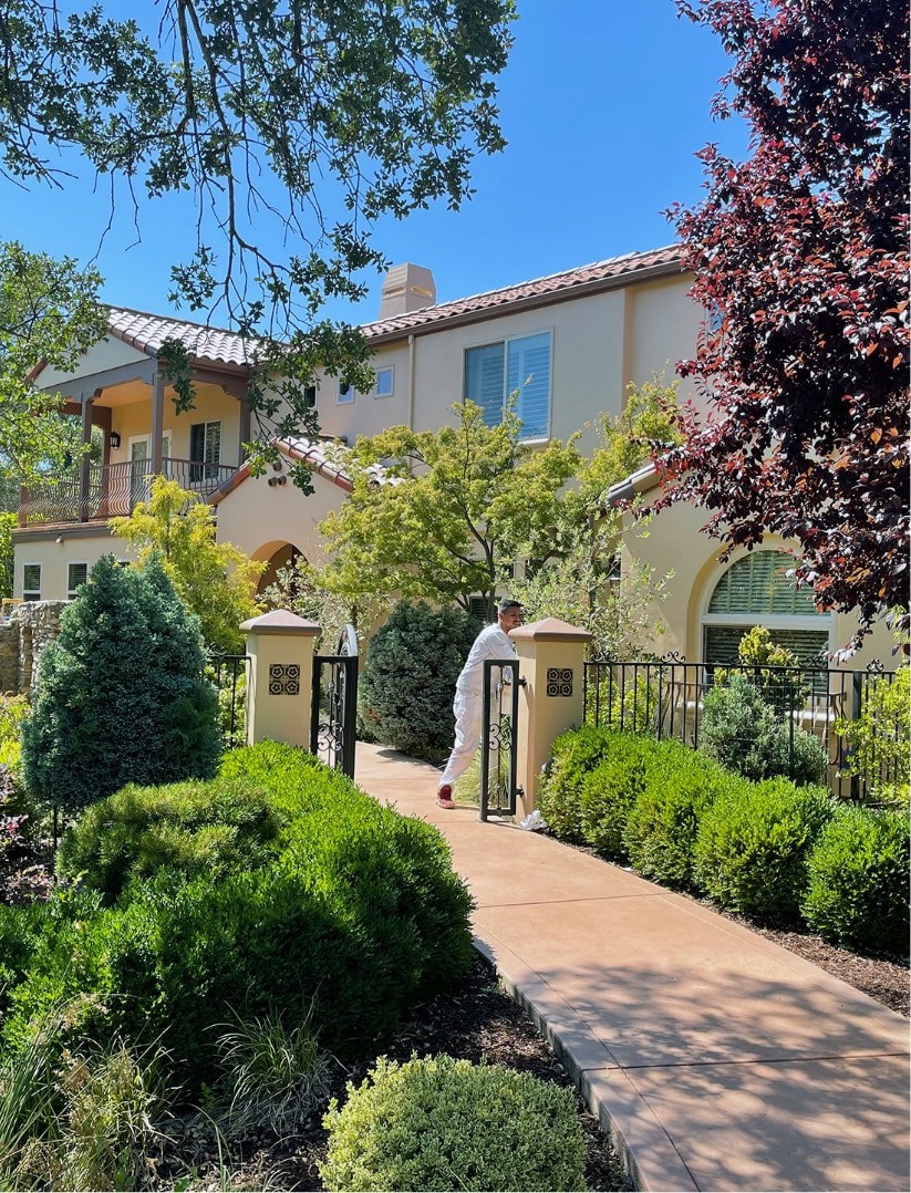 Spanish style home with bushes and landscaping